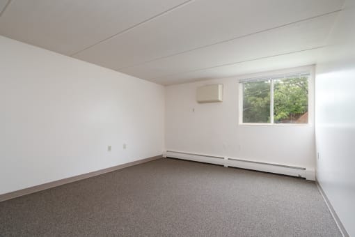 an empty room with white walls and a window