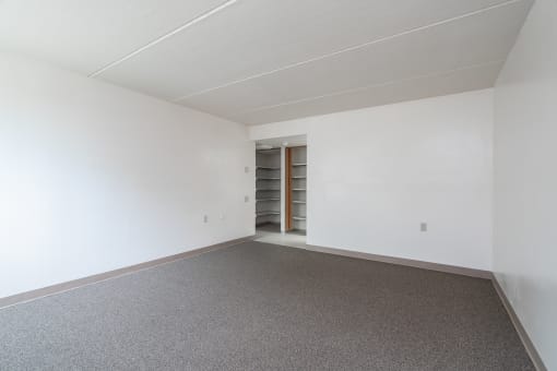 an empty room with a carpet and white walls