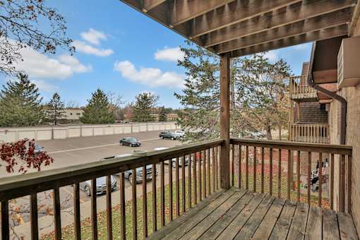 a view of the street from a balcony with a wooden deck
