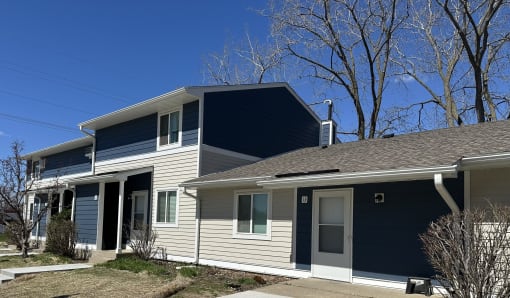 a white house with blue siding and a gray roof