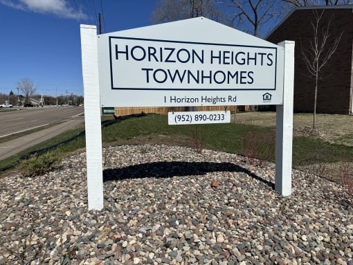 a sign for horizon heights townhomes in front of a road