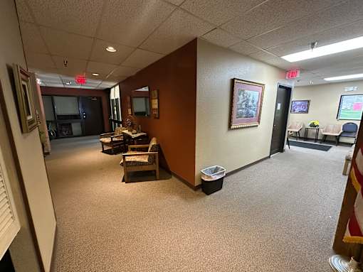 A hallway with a brown wall and a painting hanging on it.
