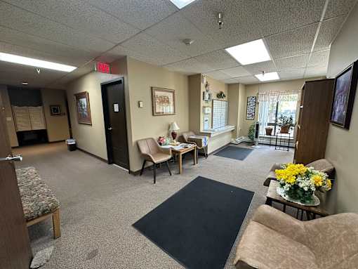 A waiting room with chairs and a couch.