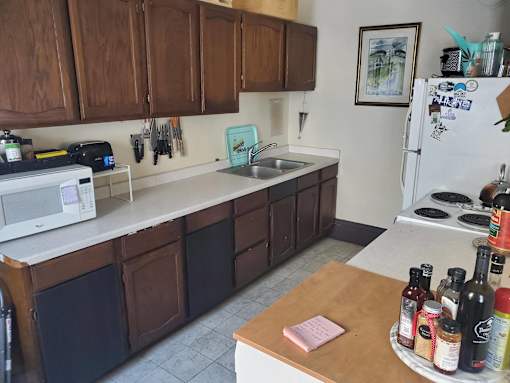 A kitchen with brown cabinets and a white fridge.