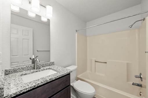 A bathroom with a sink, toilet, and bathtub.