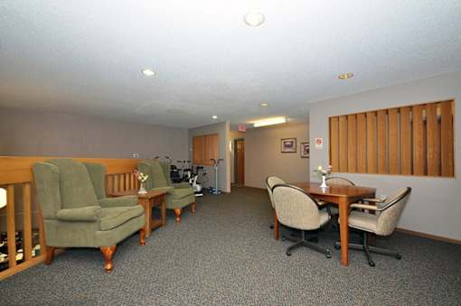 A room with a table and chairs in the middle of the room.