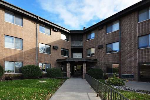 A brick building with a walkway leading to the entrance.