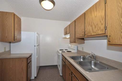 A small kitchen with a white refrigerator and a white stove.