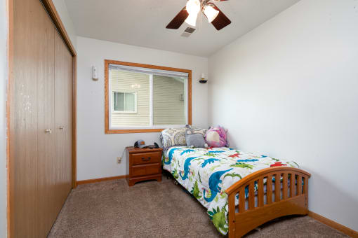 a bedroom with a bed and a dresser and a window