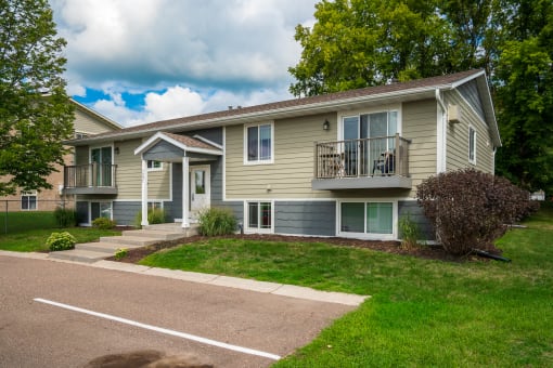 a beige house with a porch and a sidewalk