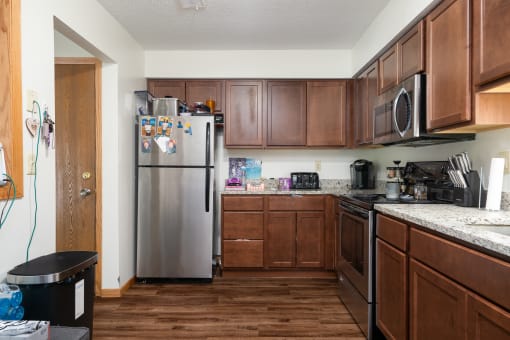 a kitchen with wooden cabinets and a stainless steel refrigerator