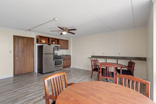 a dining room and kitchen with a wooden table and chairs