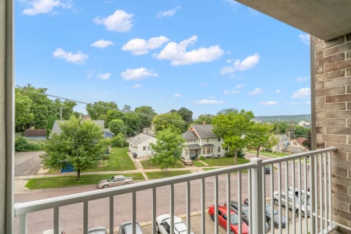 the view from the balcony of an apartment building with cars parked in a parking lot