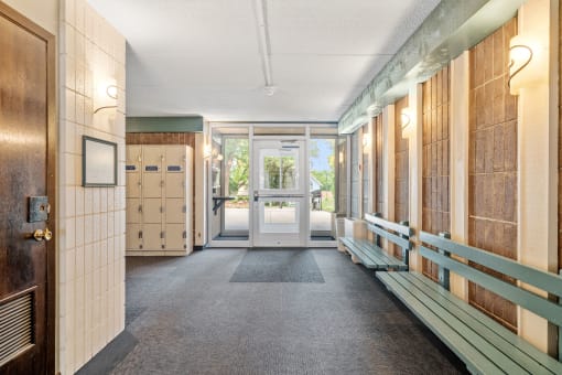 a hallway with benches and mailboxes and doors in a building