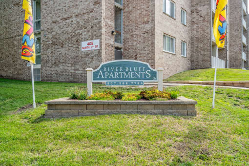the sign for riverbank apartments in front of a brick building