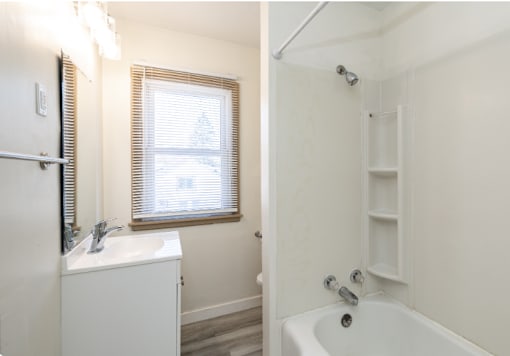 A white bathroom with a tub and sink.