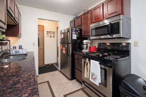 a kitchen with stainless steel appliances and a black stove and refrigerator