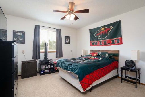 the master bedroom has a comfy bed and a ceiling fan