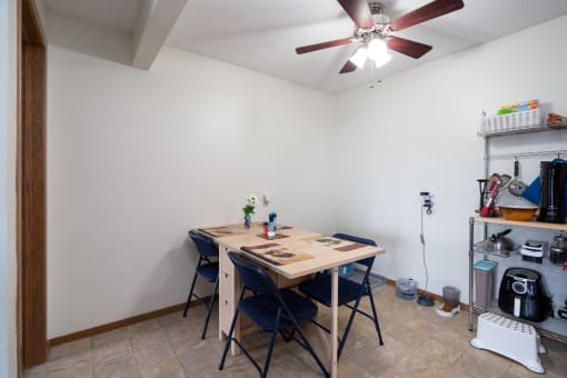 a dining room with a table and chairs and a ceiling fan