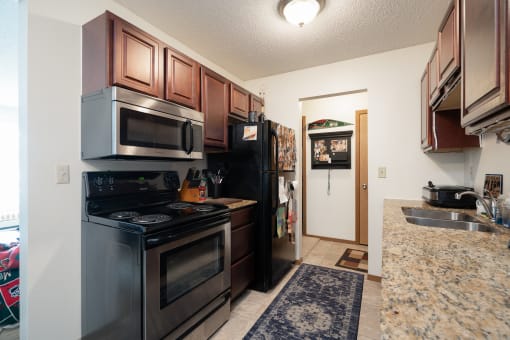 a kitchen with black appliances and a granite counter top