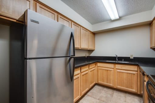 a kitchen with a stainless steel refrigerator and wooden cabinets
