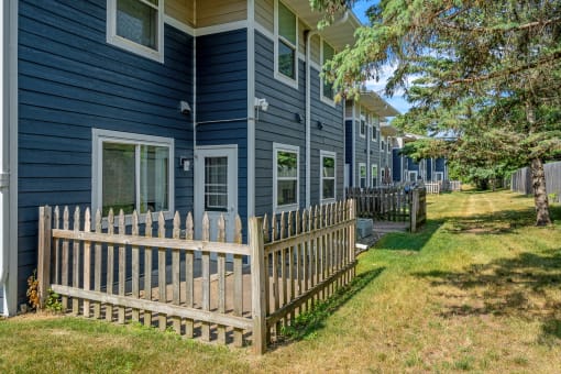 a wooden fence in front of a blue house