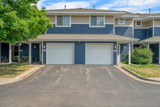a blue house with two white garage doors