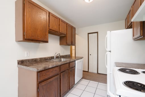 a kitchen with wooden cabinets and a white stove and refrigerator