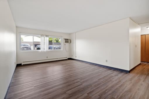 an empty living room with white walls and wood floors