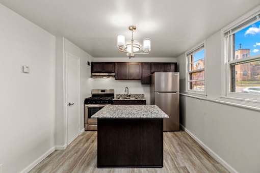 A kitchen with a refrigerator, stove, and island.