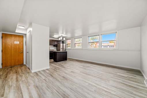 A room with a wooden door and a white wall.