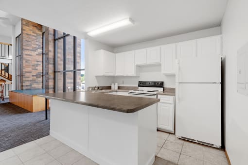 a kitchen with white cabinets and a counter top and a refrigerator