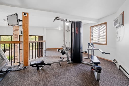 a gym with exercise equipment and a tv on the wall
