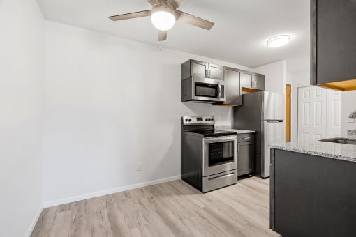 a kitchen with stainless steel appliances and a ceiling fan