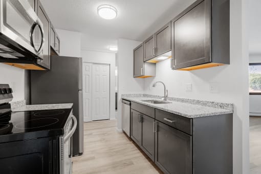 the kitchen of a modern apartment with stainless steel appliances and granite counter tops