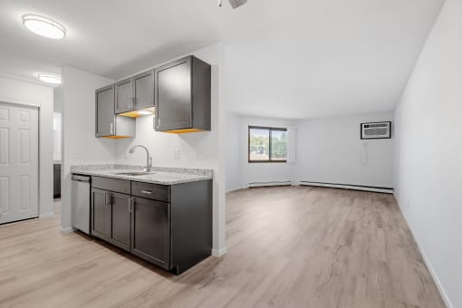 the living room and kitchen of an empty apartment