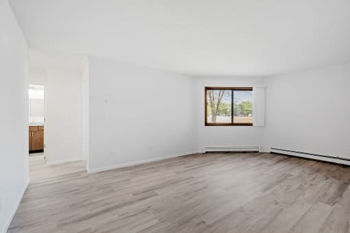 an empty living room with white walls and a window