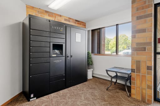 a room with a black refrigerator and a table with a window
