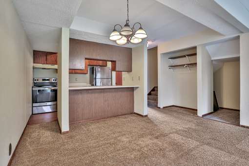 A living room with a kitchen area in the background.