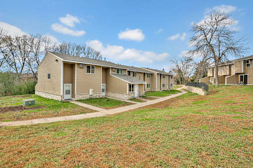 A row of houses with a grassy area in front.