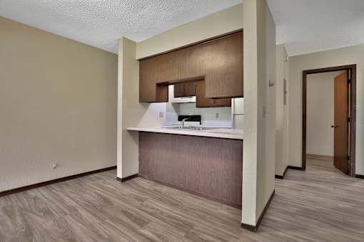 an empty apartment with a kitchen and a door