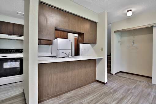 an empty kitchen with a refrigerator and a sink