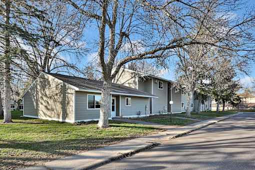 a gray house with trees in front of it