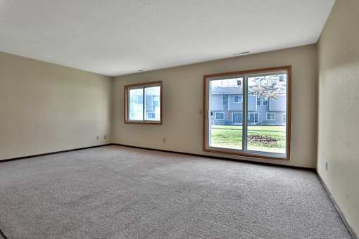 the living room of an empty house with a large window