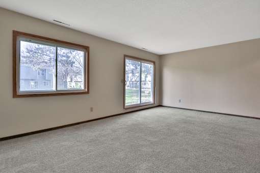 the living room of an empty house with a large window