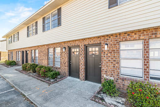 A row of houses with a black door and a sign that says "Welcome".