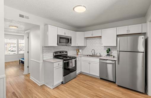 A kitchen with white cabinets and stainless steel appliances.