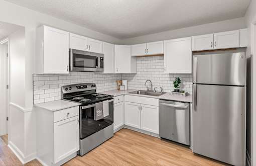 A kitchen with white cabinets and stainless steel appliances.
