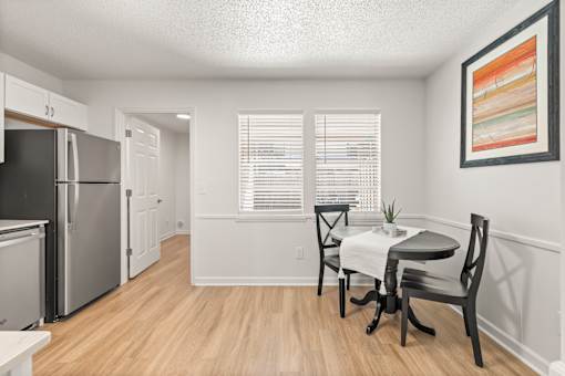 A kitchen with a dining table and chairs.