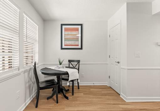 A dining room with a table and chairs.